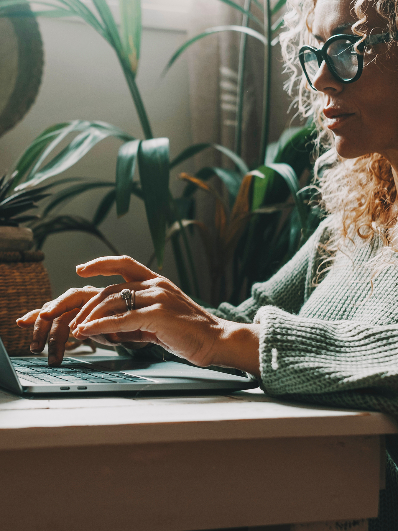 Image of a professional woman working at home on laptop writing with concentrated expression. Modern female people using computer in indoor online leisure activity. Shopping or business smart work job freelance